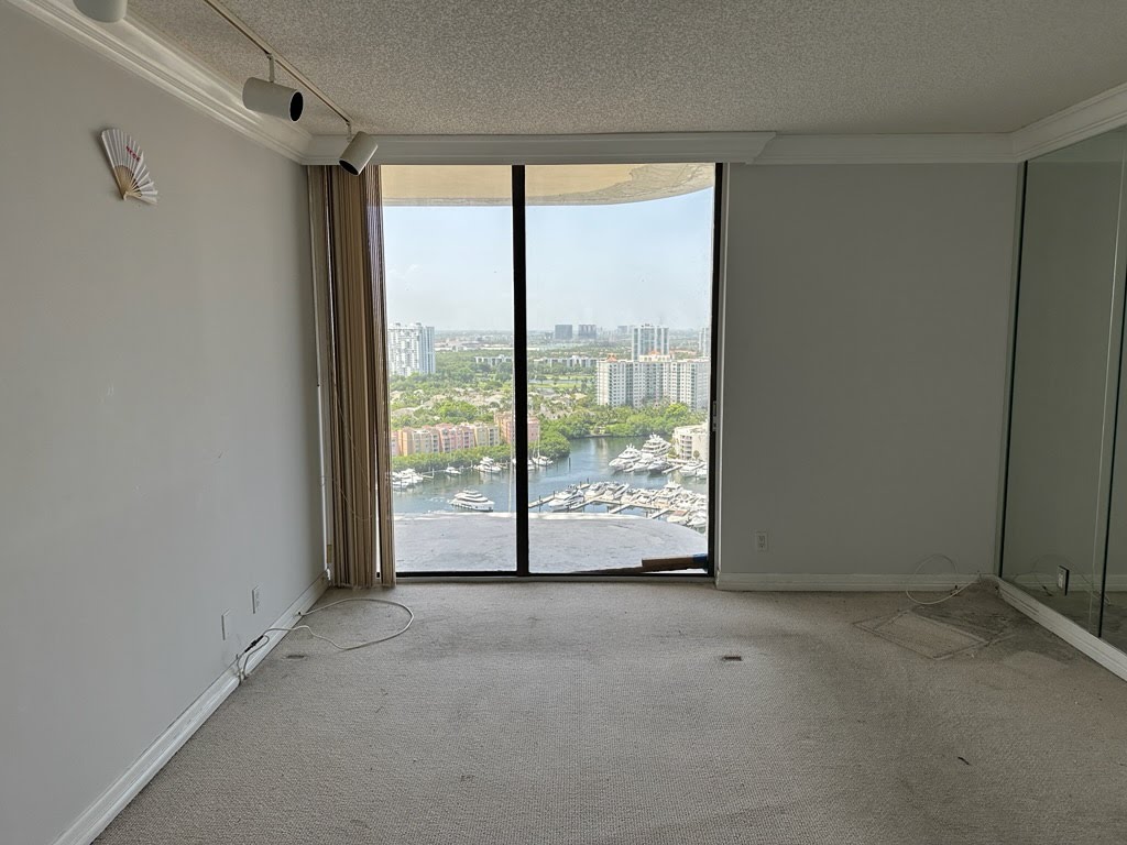 Empty high-rise condo living room after complete clearance, with Miami skyline view
